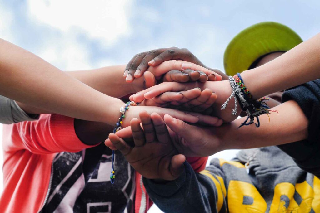Teens stacking hands together